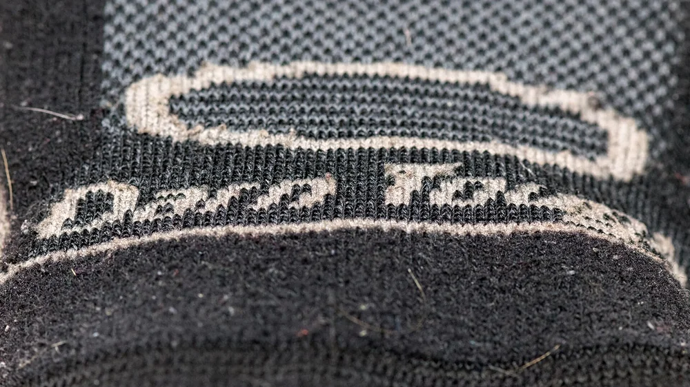 Close-up of the Darn Tough label woven into the cuff of a wool sock