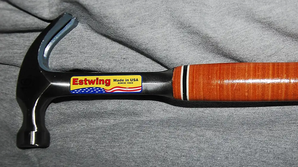 Estwing steel hammer with a stacked leather grip lying on a gray cloth