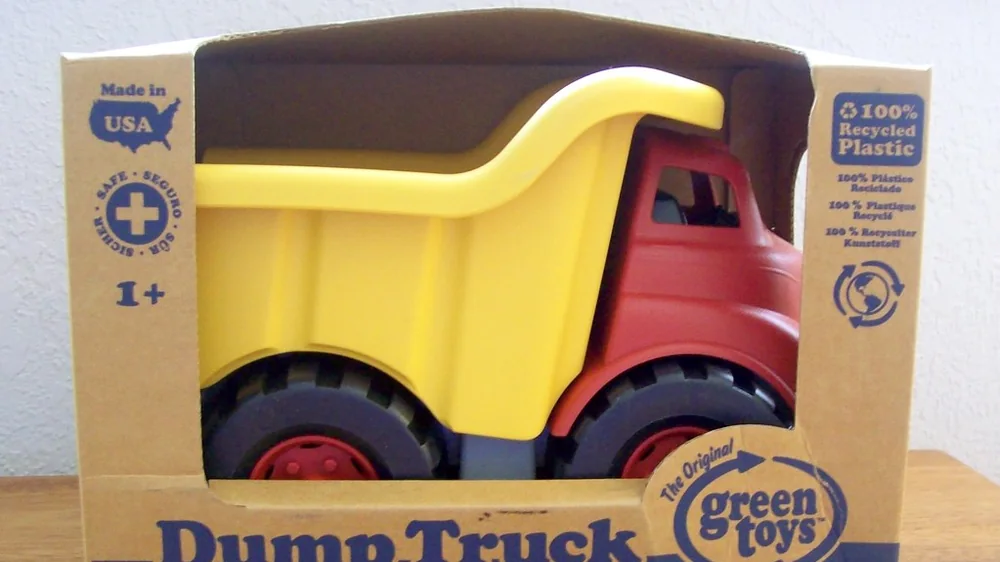 Boxed Green Toys dump truck with a yellow bed and red cab