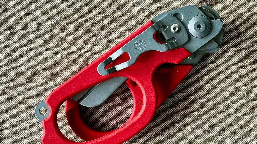 Leatherman Raptor Rescue trauma shears with a red handle on burlap