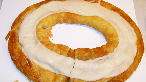 An oval iced kringle pastry on white paper. Representative photo, not the exact product.